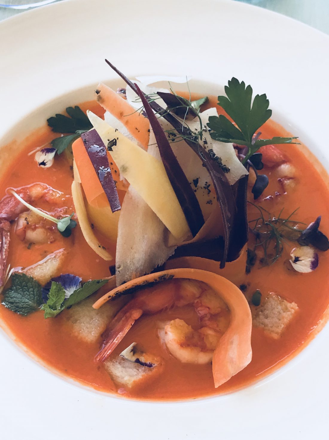 A brothy fish stew accented with shaved vegetables in Tuscany